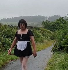 Femme de ménage travestie dans une voie publique sous the sniffles pluie